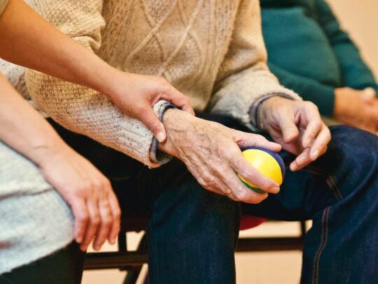 Hospice nurse holding patient's hand